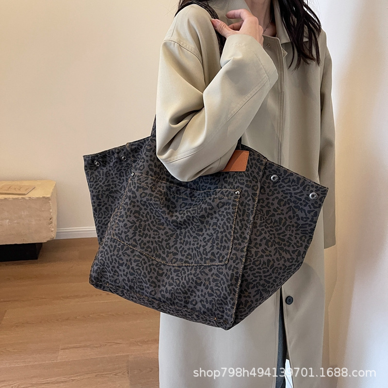 A niche leopard print canvas tote bag for women's leisure, large capacity, fashionable carrying bag, Korean version, stylish one shoulder crossbody bag